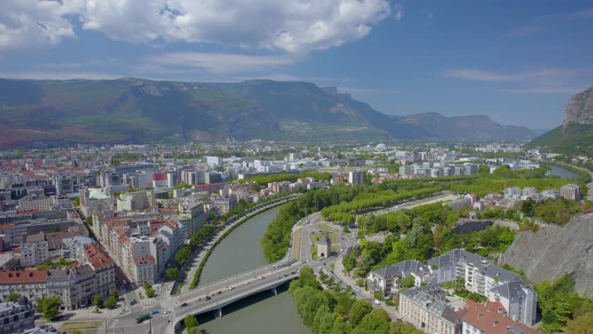 The drone aerial footage of the Isère River and Grenoble city, France. Grenoble is the prefecture and largest city of the Isère department in the Auvergne-Rhône-Alpes region of southeastern France.