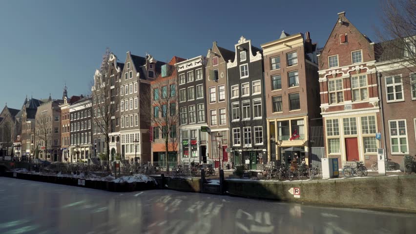 Frozen Oudezijds Voorburgwal canal in the Red-light district of De Wallen, covid 19 pandemic lockdown with an empty street, Amsterdam, The Netherlands Royalty-Free Stock Footage #1105097117