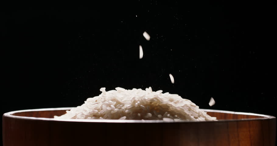 Rice being poured raw wooden bowl side view black background Sushi sashimi, Japanese Chinese Indian Asian Ethnicity cookery. Wooden rice bowl healthy clean eating. Grain seed vegan uncooked white rice Royalty-Free Stock Footage #1105099683