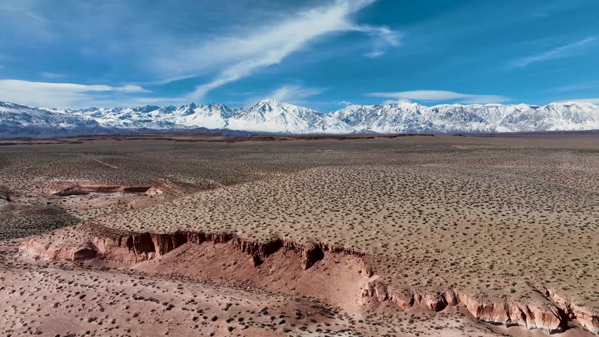 Aerial video of red cliffs on the volcanic tablelands with Sierra Nevada background near Bishop, California
