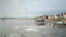Traditional Dutch village Durgerdam in the rare white winter with frozen pond and people ice skating on it, Amsterdam, Netherland - Powered by Shutterstock - Get 15% off with code: PIKWIZARD15