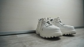 white sneakers on gray floor