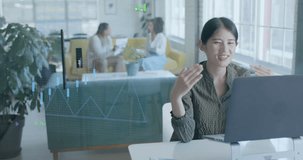 Animation of financial data over happy asian casual businesswoman on video call in office. Digital interface, finance, communication and casual business concept digitally generated video.