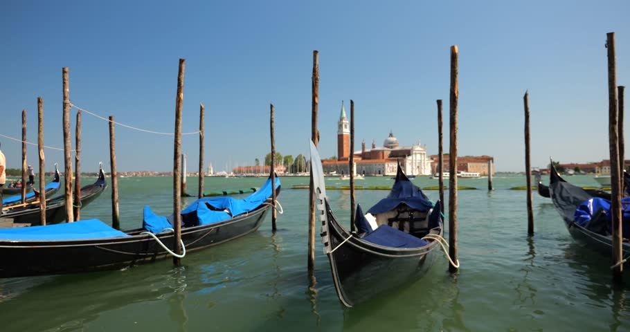 Gondolas moored with palines at the waterfront at the Riva degli Schiavoni, in Venice, Italy.