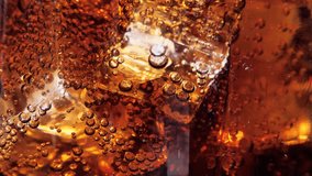 Cola with ice cubes background. Cola with Ice and bubbles in glass. Soda closeup. Food background. Stock video footage