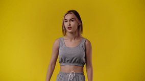 4k video of one girl who counts to three and then emotionally rejoices over yellow background.