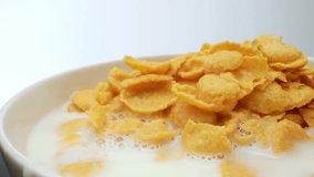 The macro footage showcasing crunchy corn flakes blending with velvety milk in a bowl. This captivating food concept will leave your taste buds longing for a delightful breakfast experience. 4K UHD
