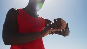 Animation of clock over african american man training in sun using smartwatch. Global connections, wellbeing, fitness and healthy lifestyle concept digitally generated video.