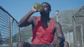 Animation of clock over african american man training in sun drinking water. Global connections, wellbeing, fitness and healthy lifestyle concept digitally generated video.