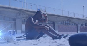 Animation of glowing lights over african american man training in sun taking a break on beach. Global connections, wellbeing, fitness and healthy lifestyle concept digitally generated video.