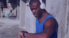 Animation of clock over running african american man in headphones using smartwatch. Global connections, wellbeing, fitness and healthy lifestyle concept digitally generated video.