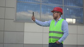 man at the construction site. a man conducts a video broadcast on a smartphone. slow motion video. High quality Full HD video recording