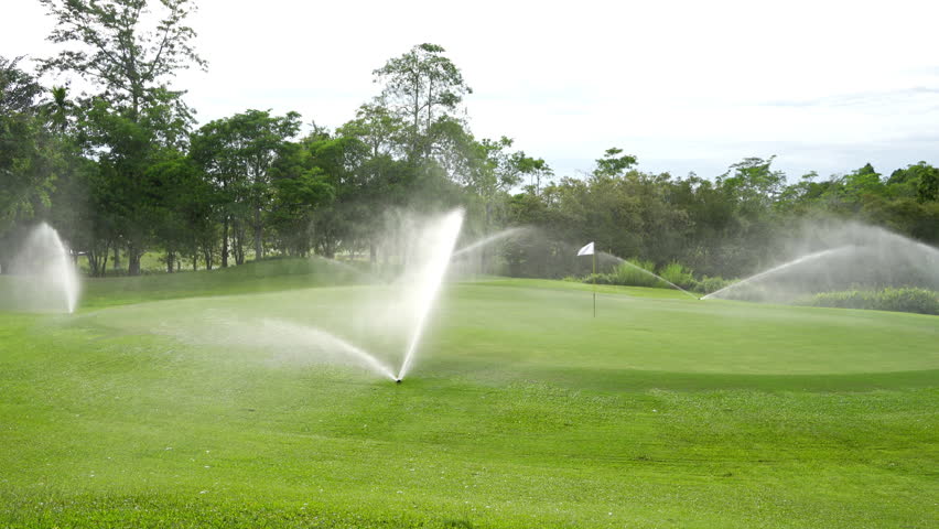 Automatic high-pressure water sprinkler at green golf course watering the grass. Royalty-Free Stock Footage #1105129337