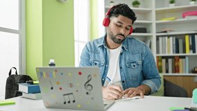 African american man student having online lesson writing notes at library university