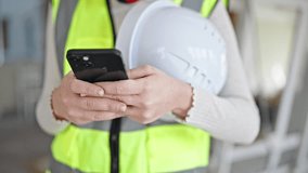 Young blonde woman architect using smartphone holding hardhat at construction site - Powered by Shutterstock - Get 15% off with code: PIKWIZARD15