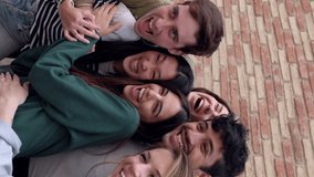 Happy group of young students hugging each other laughing outdoors. Friendly group of millennial friends having fun together at city street. Vertical video. - Powered by Shutterstock - Get 15% off with code: PIKWIZARD15