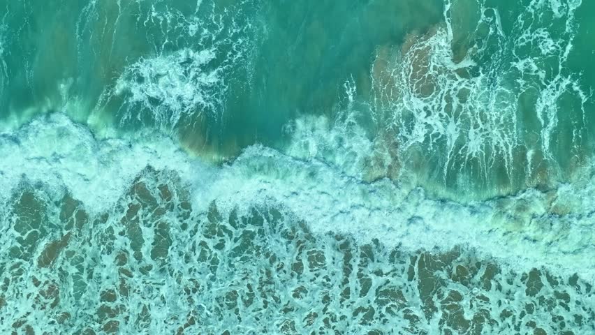 aerial top view the serene beauty of the scenery is breathtaking. 
The surface of the waves crashing on the sand breaks into beautiful patterns.
4K UHD 50 frame per second. Video slow motion Clip
 Royalty-Free Stock Footage #1105143139