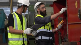 group of two diversity Electrician engineer checking electrical installations and wires on cabinet with tablet computer in factory . team arab and asian repairman maintenance in manufacturing industry - Powered by Shutterstock - Get 15% off with code: PIKWIZARD15