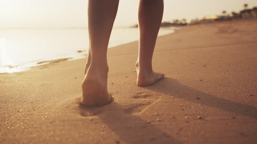 Legs of woman tourist barefooted feet walking on sandy ocean beach leaving footprints in luxury resort at sunset outdoors. Female enjoying resting on summer vacation. Travel, tourism, journey concept. Royalty-Free Stock Footage #1105149695