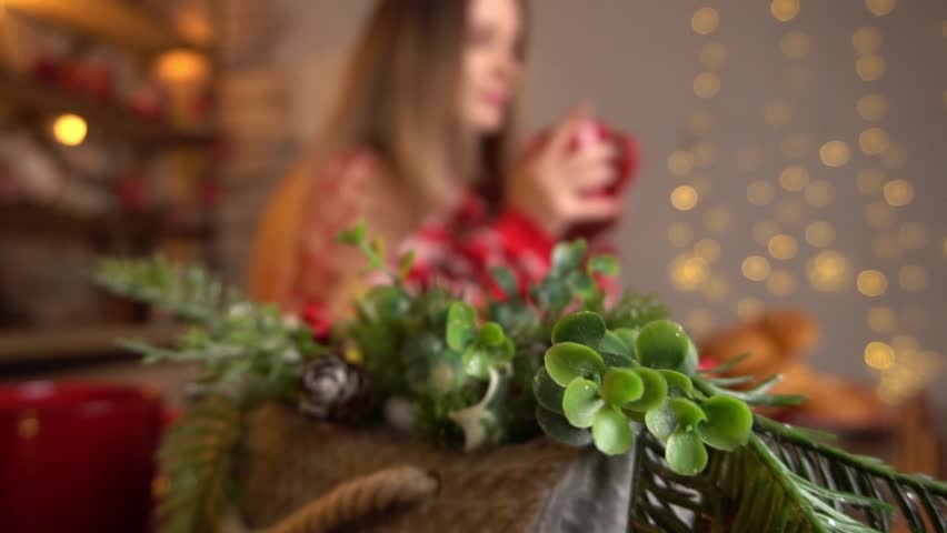 Girl in Christmas decorated kitchen and drinking coffee