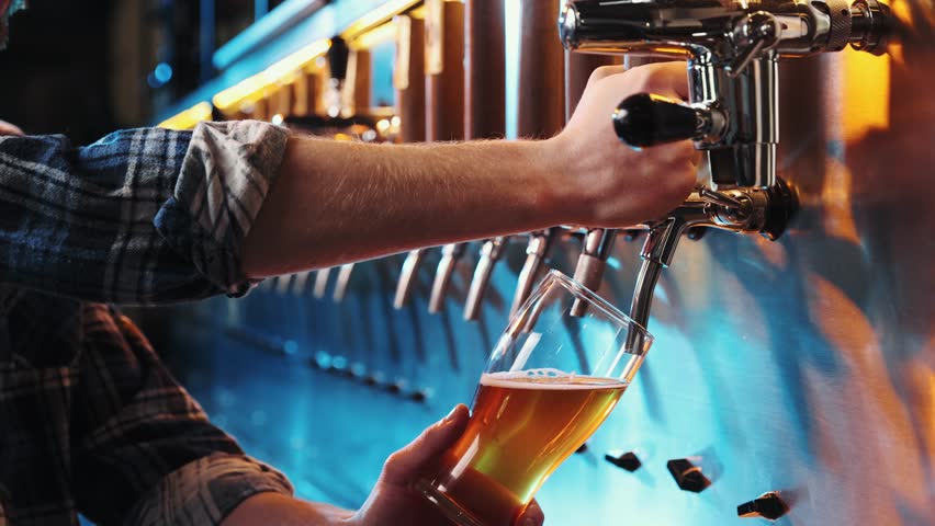 Close-up pf male hand of bartender pouring a large glass of lager beer with tap. Pouring beer for client at pub, bar. Concept of alcohol drink, party, taste, relaxation. Ad