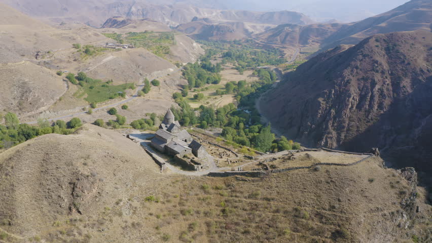 Forward reveal aerial shot of Vorotnavank Monastery on sunny summer day. Vorotan, Syunik Province, Armenia.