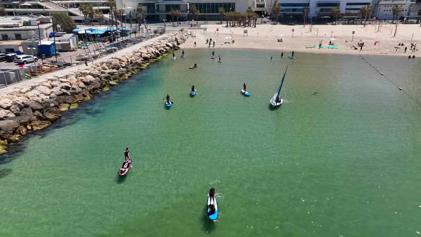 Beautiful aerial view of Tel Aviv beach during a sunny summer , hotels and city skyline view.people enjoy doing water sports. sup paddle board.