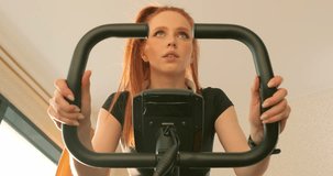 motivated fit sweaty woman with long red hair working out at home, she is tired closing eyes, slow motion tiredness motivation