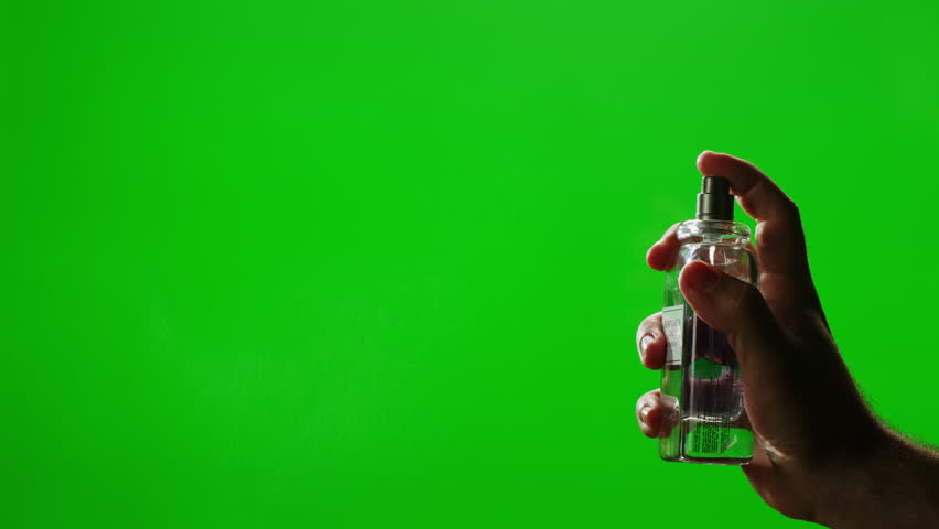 Young man applying perfume to skin on chroma key green screen, close up of spraying deodorant luxury perfume.