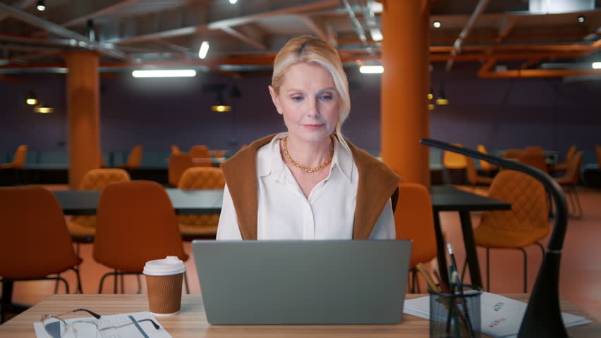 Tired mature business woman lawyer wearing eyeglasses working looking at laptop computer screen reflecting in glasses, analyzing online finance data. Finishing work day at late night, closing laptop Royalty-Free Stock Footage #1105172961