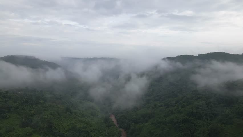 Clouds Over valley of Garo Hills In Meghalaya, India. Misty fog blowing over tree forest. Aerial footage of rain forest on the mountain hills at misty day. Morning monsoon flying through Khasi Hills Royalty-Free Stock Footage #1105177997