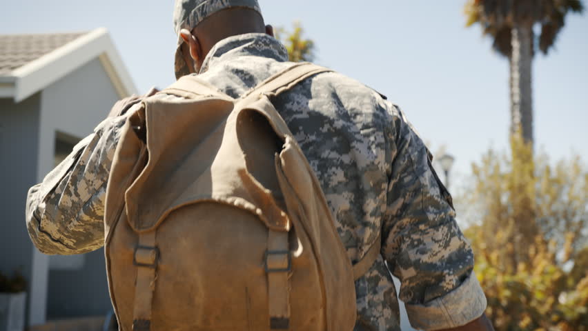 Soldier walks towards his house upon returning from the military. This rearview of the patriot, in uniform and carrying a backpack, shows his honorable discharge and the end of his service as a marine Royalty-Free Stock Footage #1105185529