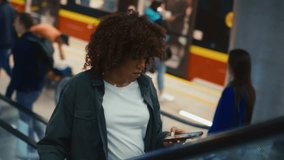 Young black woman moving on escalator in underground tube. Shot with RED helium camera in 8K. 