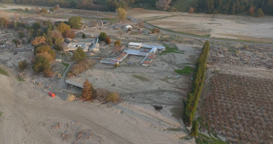 Aerial: buildings destroyed by flood silt. Caused the floods of Cyclone Gabrielle in February 2023. Esk Valley, Napier, New Zealand.  Royalty-Free Stock Footage #1105188145