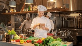 Portrait of cook holding gadget and preapering to cook delicious dishes. Male chef looking for new recipes on digital tablet in professional kitchen. Concept of restaurant food gastronomy. - Powered by Shutterstock - Get 15% off with code: PIKWIZARD15