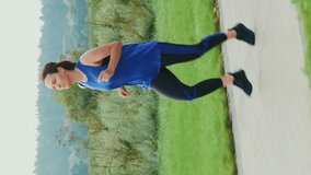 Woman running outdoors. Sportive female jogging in city park. Vertical video. Sportswoman doing intense cardio fitness exercises. Sport concept. Sport motivation