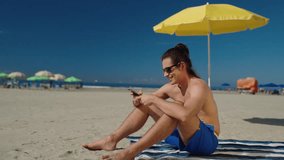 relaxed caucasian man hold use smart phone watching social media sitted at the beach 
 - Powered by Shutterstock - Get 15% off with code: PIKWIZARD15