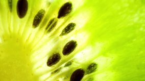 Close-up macro footage capturing the intricate details of a halved kiwi fruit, displaying its fuzzy brown exterior contrasting beautifully with the vibrant green flesh. Fruit concept. Kiwi background
