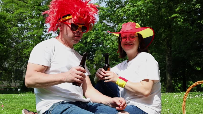 A young kissing couple celebrate Belgium Day at a picnic.