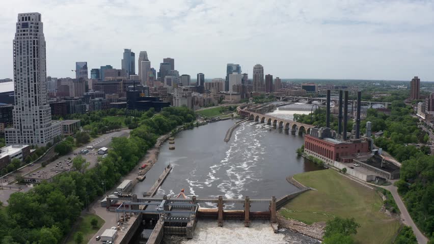 Wide aerial descending shot of Saint Anthony Falls on the Mississippi River in downtown Minneapolis, Minnesota. 4K