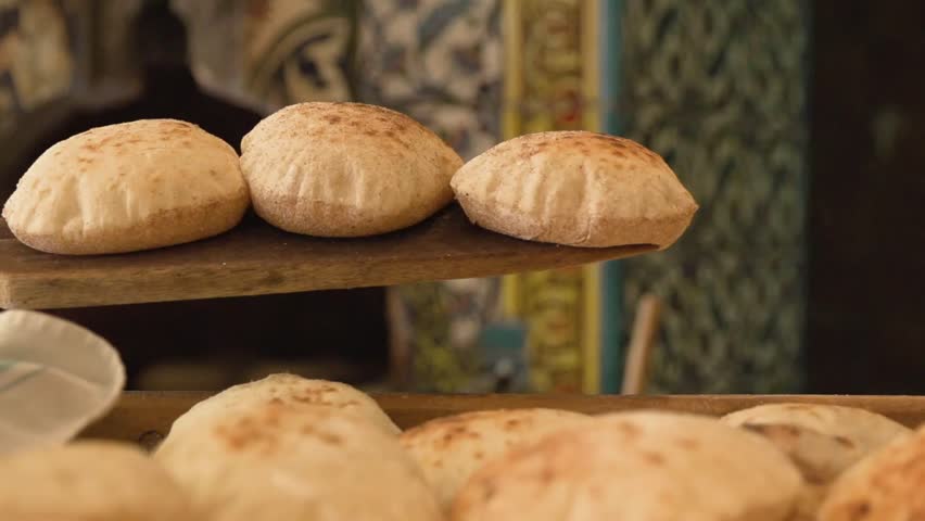 Freshly Baked Bread Being Taken Out Of Traditional Oven on Wooden Paddle and Served in Bakery