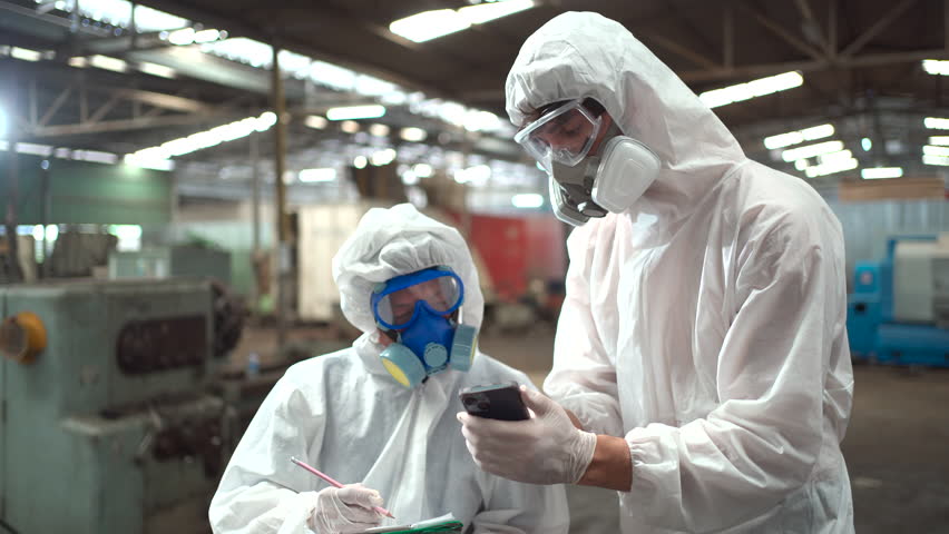 Team of scientist wearing a chemical protection suit and high efficiency filter face mask working in the bio - chemical contaminated factory. Bio chemical scientists working in the hazardous area. Royalty-Free Stock Footage #1105204561