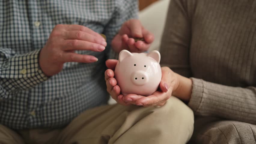 Saving money investment for future. Senior adult mature couple hands holding piggy bank putting money coin. Old man woman counting saving money planning retirement budget. Investment banking concept Royalty-Free Stock Footage #1105211321