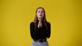 4k video of girl begging for something on yellow background.