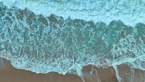 aerial top view the serene beauty of the scenery is breathtaking. 
The surface of the waves crashing on the sand breaks into beautiful patterns.
4K UHD 50 frame per second. Video slow motion Clip
