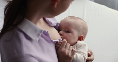 Close up cute three-month-old baby drinks moms breast milk, enjoy moment of closeness and care. Concept of healthcare, breastfeeding provides nutritional components, strengthen immune, infancy concept Video de stock