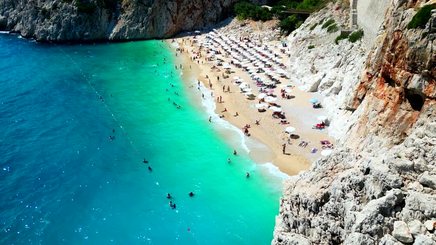 Kaputaş Beach with its famous bright turquoise sea is not only one of the most beautiful beaches on the Lycian Coast, but it's considered to be one of the most beautiful beaches in all of Turkey. Royalty-Free Stock Footage #1105228355