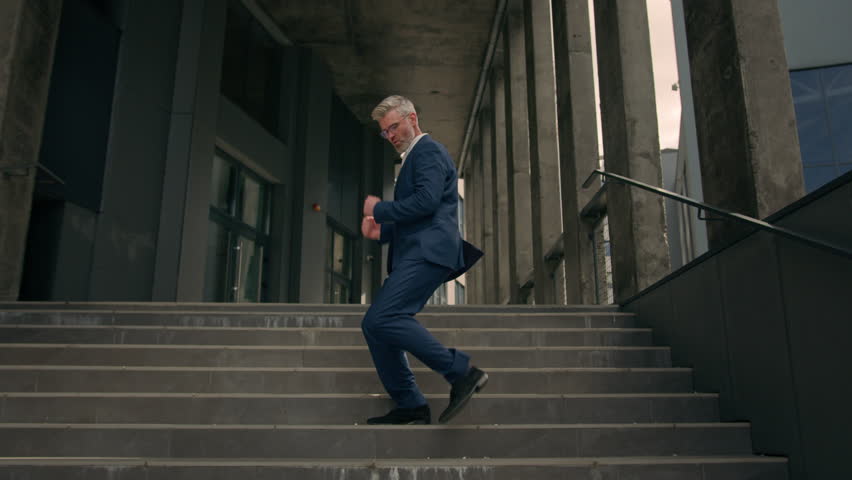 Happy Caucasian senior business worker employee mature man businessman dancing walking on stairs near office building outside outdoors funny moving dance success celebrate victory achieve having fun Royalty-Free Stock Footage #1105234511