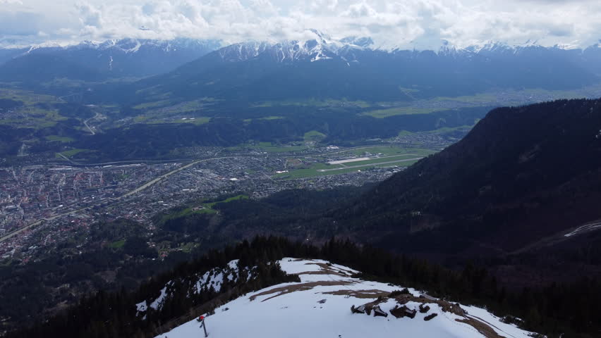 Aerial view looking down valley over city of Innsbruck and Nordkette snowy mountain range, Austria Tyrol capital