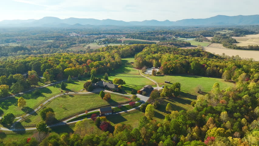Big expensive residential house surrounded with farm fields and dense forest in rural North Carolina